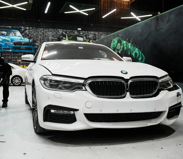 White BMW 5 Series M Sport in a service bay at System X Car Care in Al Quoz, Dubai, Dubai.
