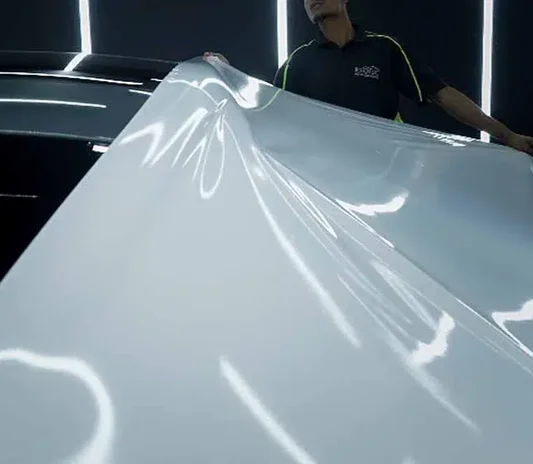 Technician fitting and smoothing film edges during installation in Dubai