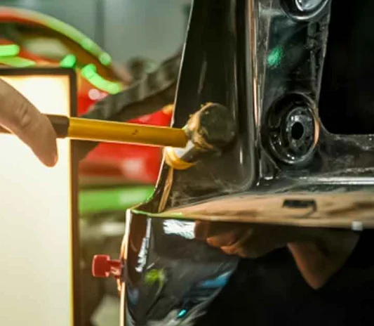 Paintless dent repair being carried out on a car panel in Al Quoz, Dubai, Dubai