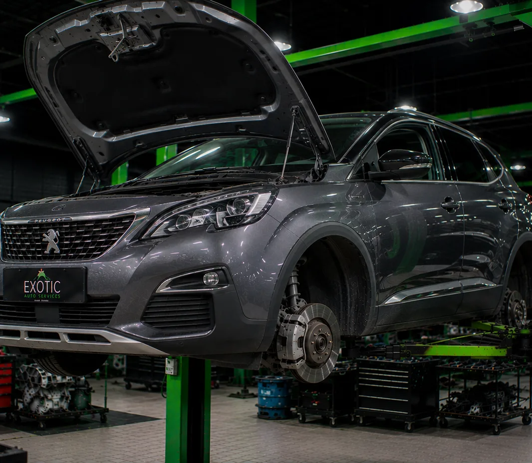 A car on a two-post lift with the wheels off, in the Dubai workshop