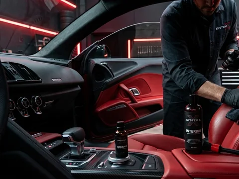 Technician cleaning luxury car leather interior at the System X Car Polish workshop in Dubai