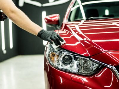 Car service worker applying nano coating on a car detail